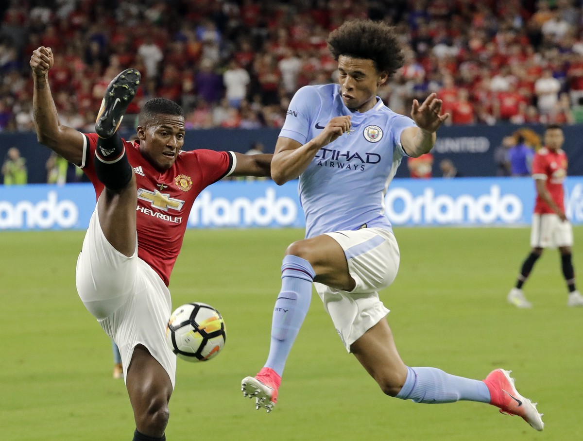 Manchester United's Luis Antonio Valencia, left, tries to block a drive by Manchester City's Leroy Sane, right, during the second half of an International Champions Cup soccer match in Houst ...
