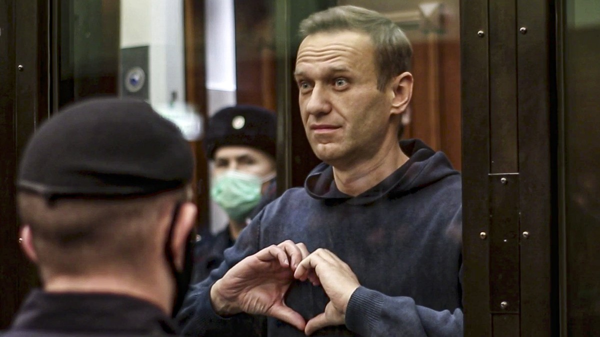 FILE - In this handout photo taken from video provided by the Moscow City Court on Feb. 2, 2021, Russian opposition leader Alexei Navalny shows a heart symbol while standing in a defendants' cage ...