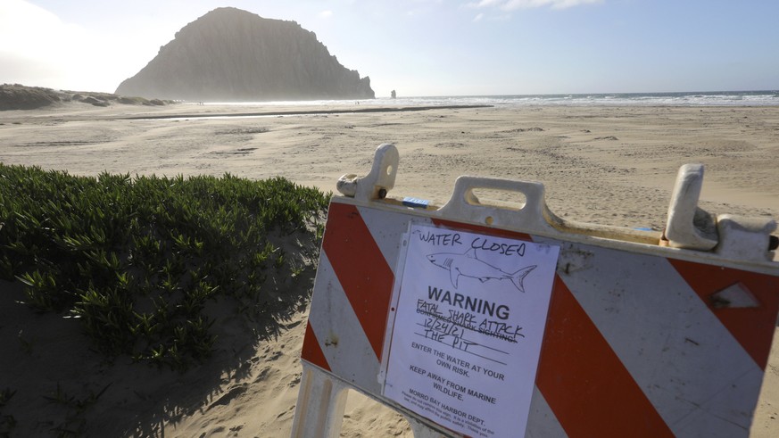 A sign on a parking lot announces a beach closure Friday, Dec. 24, 2021, in Morro Bay, Calif. A surfer was killed in an apparent shark attack on Christmas Eve off the central coast of California, auth ...