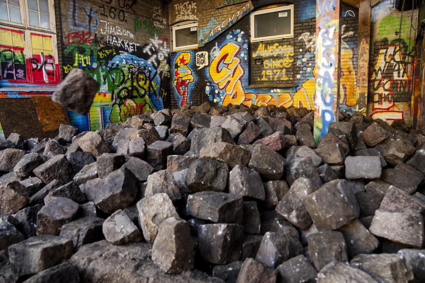 epa11263005 Residents of the free village Christiania jointly dig up the cobblestones at Pusher Street in Copenhagen, Denmark, 06 April 2024. Christiania residents carried out the action in cooperatio ...