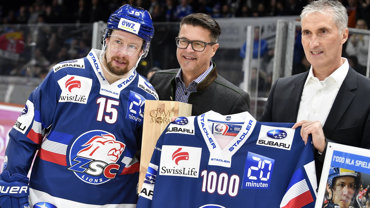 Ehrung fuer Mathias Seger, links, fuer sein 1000 Spiel von Bruno Vollmer, Mitte, Spielbetrieb ZSC Lions und CEO Ruedi Zahner, rechts, beim Eishockeyspiel der National League ZSC Lions gegen den HC Lug ...