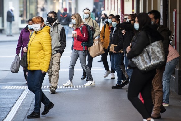 Personen tragen Masken zu den verschaerften Coronaschutzmassnahmen, am Montag, 19. Oktober 2020, bei der Bushaltestelle Loeb in Bern. Die Maskentragpflicht gilt nebst allen oeffentlich zugaenglichen R ...