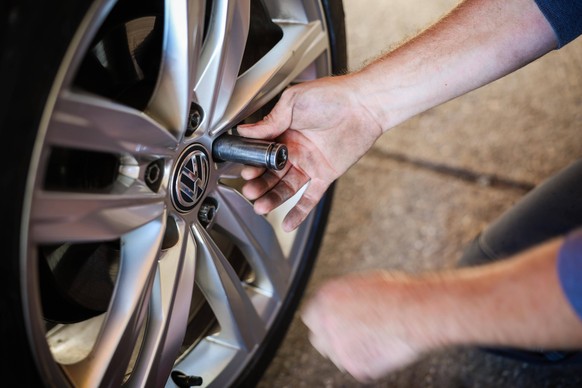 07.10.2024, Geretsberg, AUT, Unterwegs in Innviertel, Symbolbild, Themenbild, Verschiedene Themenbilder, Reifen Wechsel, im Bild Ein Mechaniker montiert Winterreifen an einem Auto in einer KFZ-Werksta ...