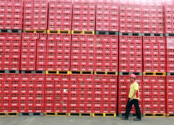 epa05777573 (FILE) - A file photo dated 14 May 2013 showing an Indonesian worker walking past crates at the Coca Cola Amatil plant in Cibitung, Indonesia. The Coca-Cola Company is to release their 201 ...