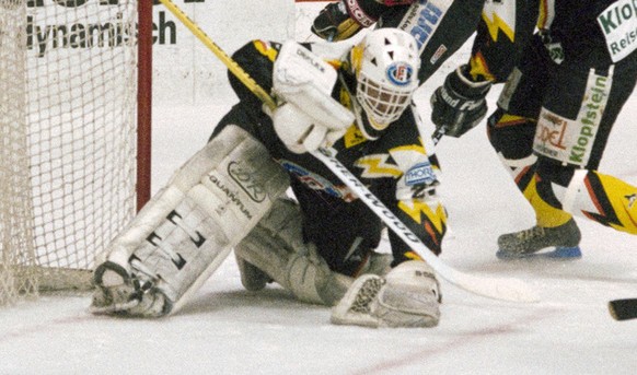 Goalie Dino Stecher, HC Fribourg-Gotteron, abgeschirmt von zwei seiner Verteidigern, haelt den Puck sicher unter Kontrolle, aufgenommen im April 1992 in einem Plyoff Finalspiel gegen den SC Bern im Al ...