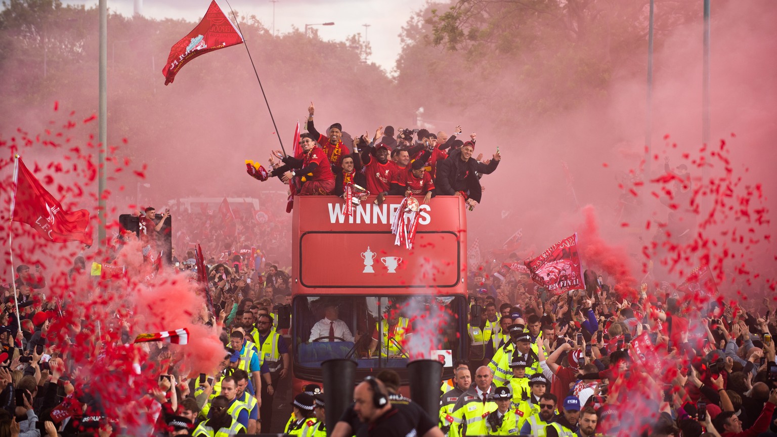 epa09985581 Liverpool supporters greet their team during an open top bus parade where the English Premier League soccer club displays the FA Cup and the Carabao Cup trophies through the streets of Liv ...