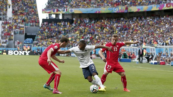 Switzerland&#039;s Xherdan Shaqiri, right, and Stephan Lichtsteiner, left, fight for the ball with France&#039;s Patrice Evra during the group E preliminary round match between Switzerland and France  ...