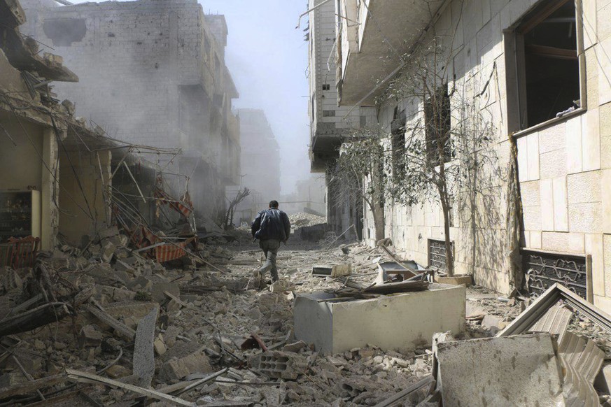 Ein Mann bringt sich im Damaszener Vorort Ghuta vor Luftangriffen der Regierung in Sicherheit.