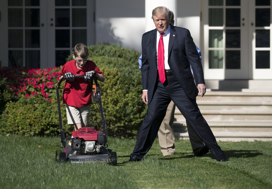 epa06206523 US President Donald J. Trump (R) walks with Frank 'FX' Giaccio (L) as he mows the Rose Garden of the White House in Washington, DC, USA, 15 September 2017. President Trump accept ...