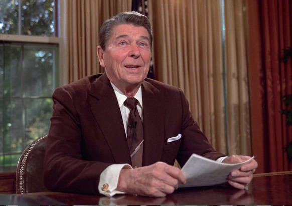 FILE - In this May 24, 1985 file photo, President Ronald Reagan works at his desk in the Oval Office of the White House as he prepares a speech on tax revision in Washington. President Barack Obama&#0 ...