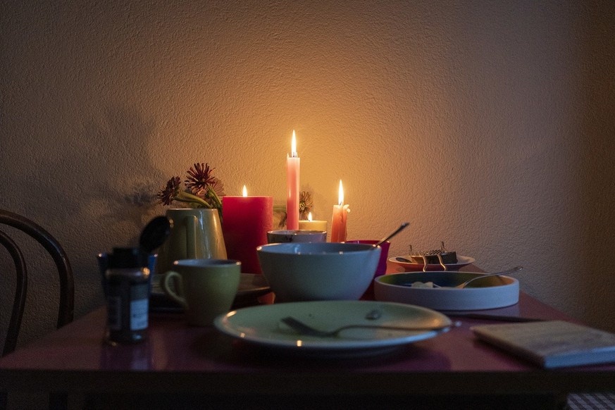 Kerzen beleuchten den Kuechentisch einer Berner Wohnung, fotografiert am Dienstag, 27. September 2022. (KEYSTONE/Christian Beutler)