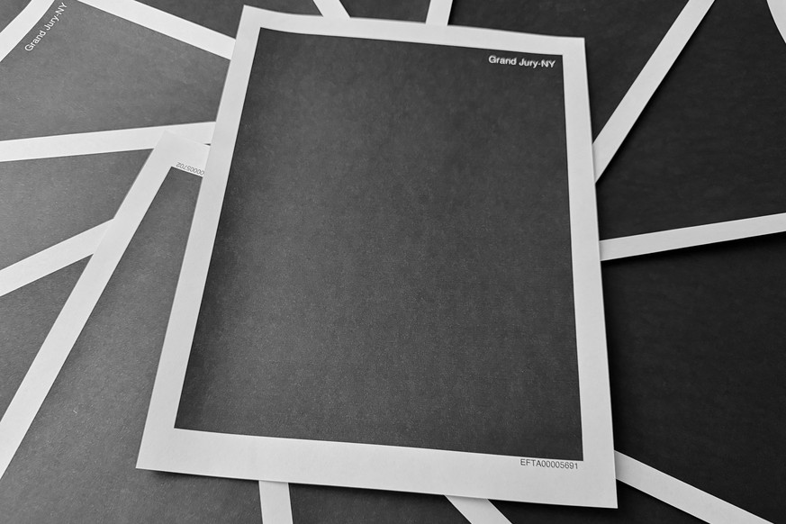 KEYPIX - Pages from a totally redacted New York grand jury file into Jeffrey Epstein and Ghislaine Maxwell, released by the U.S. Justice Department, is photographed Friday, Dec. 19, 2025, in Washingto ...