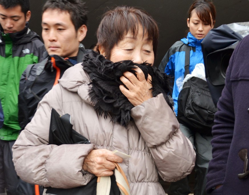 FILE - In this undated photo, Chisako Kakehi, center, answers to a reporter&#039;s question in Sakai, western Japan. A Japanese court has sentenced the woman to hang in a serial poisoning murder case  ...