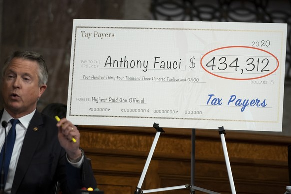 epa09679256 A visual aid presented by Sen. Roger Marshall (R-Kan.) of the yearly pay received by Dr. Anthony Fauci, White House Chief Medical Advisor and Director of the NIAID, is seen during a Senate ...