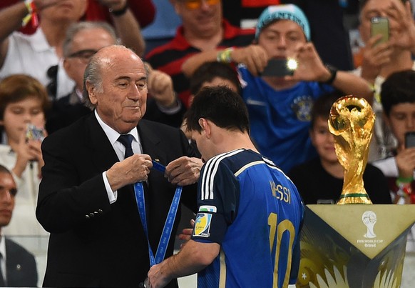 Nicht den Pokal, nur die Silbermedaille kriegt Lionel Messi von Sepp Blatter.