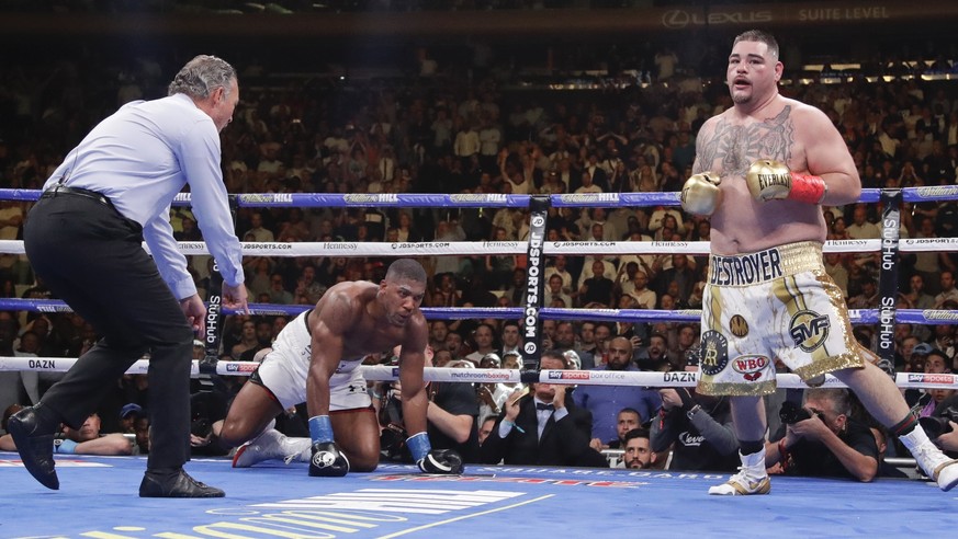 Andy Ruiz, right, heads for a neutral corner after knocking down Anthony Joshua, center, during the seventh round of a heavyweight championship boxing match Saturday, June 1, 2019, in New York. (AP Ph ...