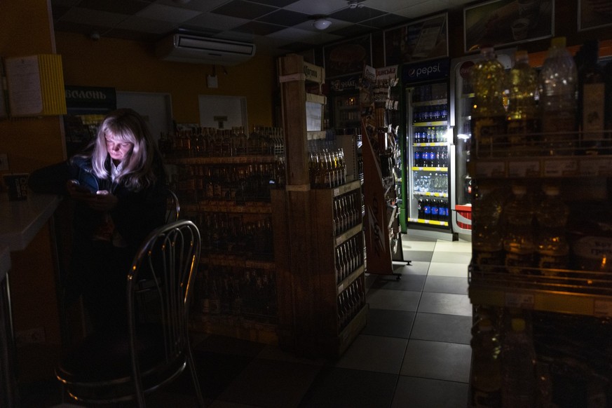 KYIV, UKRAINE - OCTOBER 28: At the BRSM gas station an employee stands inside the shop during a power outage on October 28, 2022 in Kyiv, Ukraine. As rolling power outages continue in the capital city ...