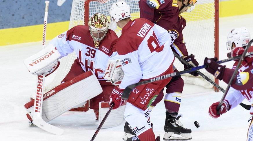 Le joueur lausannois, Joel Vermin, centre, a la lutte pour le puck avec le joueur genevois, Kevin Romy, droite, auteur du 1.0, devant le gardien lausannois, Cristobal Huet, gauche, lors du match du ch ...