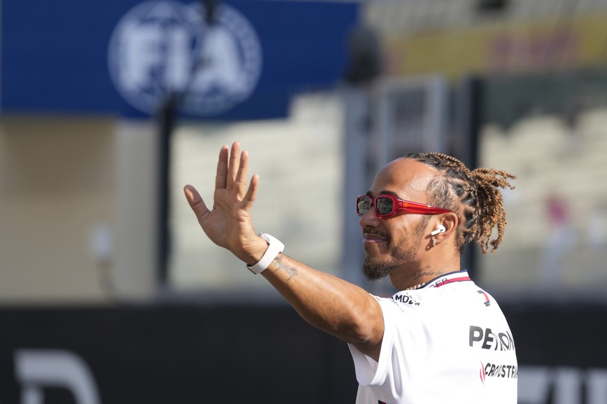 Mercedes driver Lewis Hamilton of Britain, waves as he arrives for the F1 drivers group picture ahead the drivers parade prior to the Abu Dhabi Formula One Grand Prix at the Yas Marina racetrack in Ab ...