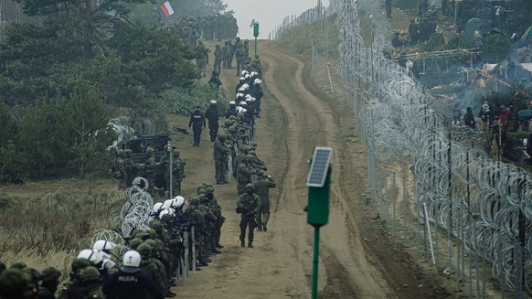epa09578268 A handout photo made available by Polish Territorial Defence Force shows Polish soldiers, police forces and border guard officers guard the fence during &#039;Operation Strong Support&#039 ...