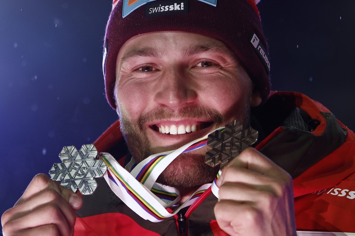 Switzerland's Alexis Monney shows his silver medal for a men's team combined event, left, and his bronze medal for a downhill race, at the Alpine Ski World Championships, in Saalbach-Hinterg ...