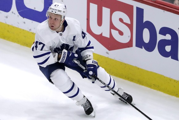 Toronto Maple Leafs center Leo Komarov, right, looks to pass against Chicago Blackhawks defenseman Jordan Oesterle during the third period of an NHL hockey game Wednesday, Jan. 24, 2018, in Chicago. T ...