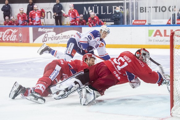 Zuerichs Raphael Prassl, links kaempft um den Puck gegen Rapperswils Torhueter Noel Bader, rechts, im Eishockeyspiel der National League zwischen den Rapperswil-Jona Lakers und den ZSC Lions am Samsta ...