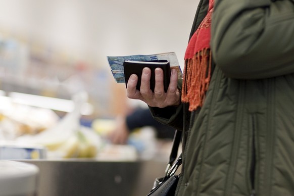 A customer has her wallet ready in her hands at a branch of supermarket chain Aldi Suisse in Ilanz in the canton of Grisons, Switzerland, pictured on March 13, 2009. (KEYSTONE/Gaetan Bally)

Eine Kund ...