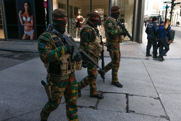 epa05038584 Soldiers and police patrol on the main shopping street Rue Neuve following the terror alert level being raised to 4/4, in Brussels, Belgium, 23 November 2015. Brussels remained on high ale ...