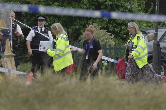 FILE - Police officers investigate after a car crashed into a primary school building in Wimbledon, London, Thursday, July 6, 2023. British police say a second 8-year-old girl has died after a car cra ...
