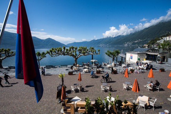 epa08427464 Locals and tourists alike enjoy the sunny weather on the shores of Lake Maggiore in Ascona, Switzerland, 17 May 2020. Tourism is returning to the Italian-speaking canton of Ticino as Switz ...