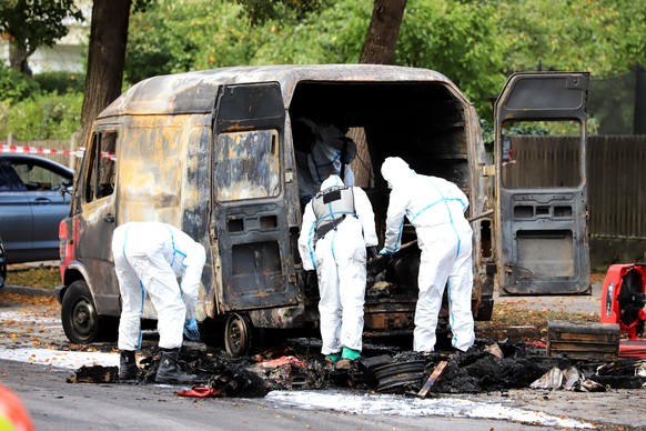 epa12420483 Police officers from the forensic unit at the scene of a burned vehicle after a fire in Munich, Germany, 01 October 2025. The Oktoberfest grounds in Munich will remain closed until at leas ...