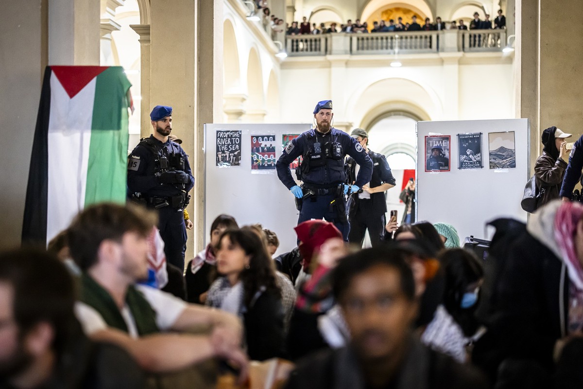 Police officers supervise Pro-Palestinian demonstrators during protest in the entrance hall of the main building of the ETH Zurich on Tuesday, May 7, 2024 in Zurich, Switzerland. (KEYSTONE/Michael Buh ...