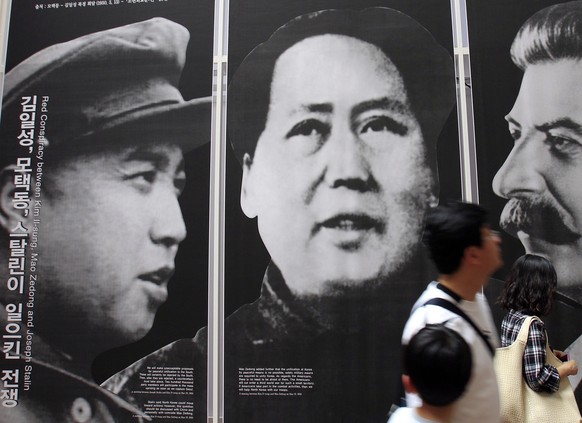 FILE - In this May 21, 2010, file photo, visitors look at posters of the late leaders, from left, of North Korea's Kim Il Song, China's Mao Zedong and Russia's Joseph Stalin at a Korean War exhibition ...