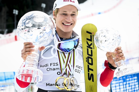 Marco Odermatt of Switzerland poses with the men's overall crystal globe trophy and the men's Giant-Slalom overall leader crystal globe trophy after the podium ceremony at the FIS Alpine Skiing World  ...