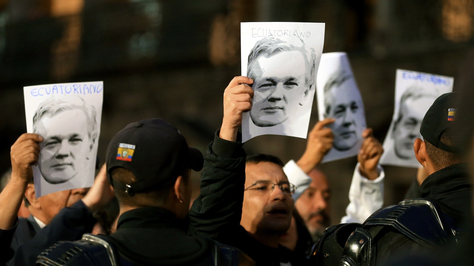 epa07134379 People hold posters with images of WikiLeaks founder Julian Assange during a support rally in front of the Carondelet Palace in Quito, Ecuador, 31 October 2018. Supporters of former Ecuado ...