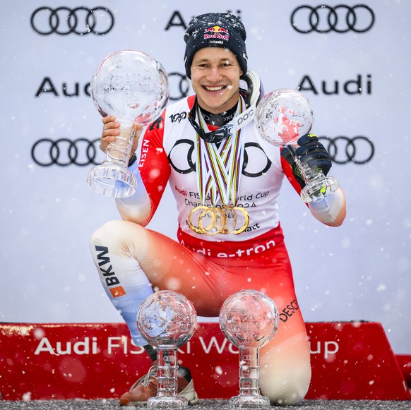 Marco Odermatt of Switzerland celebrates with men&#039;s world cup overall crystal globe trophy, the men&#039;s downhill overall leader crystal globe trophy, the men&#039;s super-g overall leader crys ...