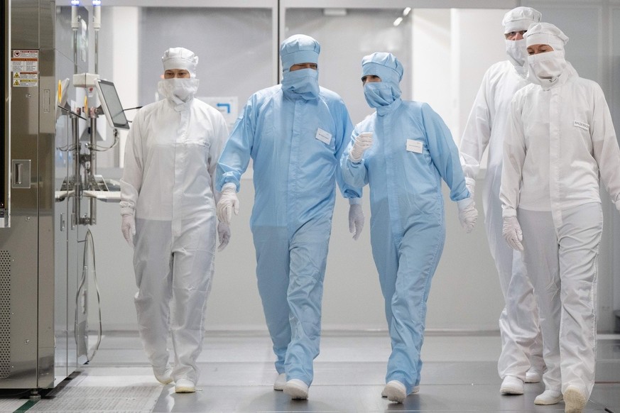 epa10744110 German Economy and Climate Protection Minister Robert Habeck (2L) and German Foreign Minister Annalena Baerbock (3L) walk in the clean room of the Infineon chip factory in Dresden, Germany ...