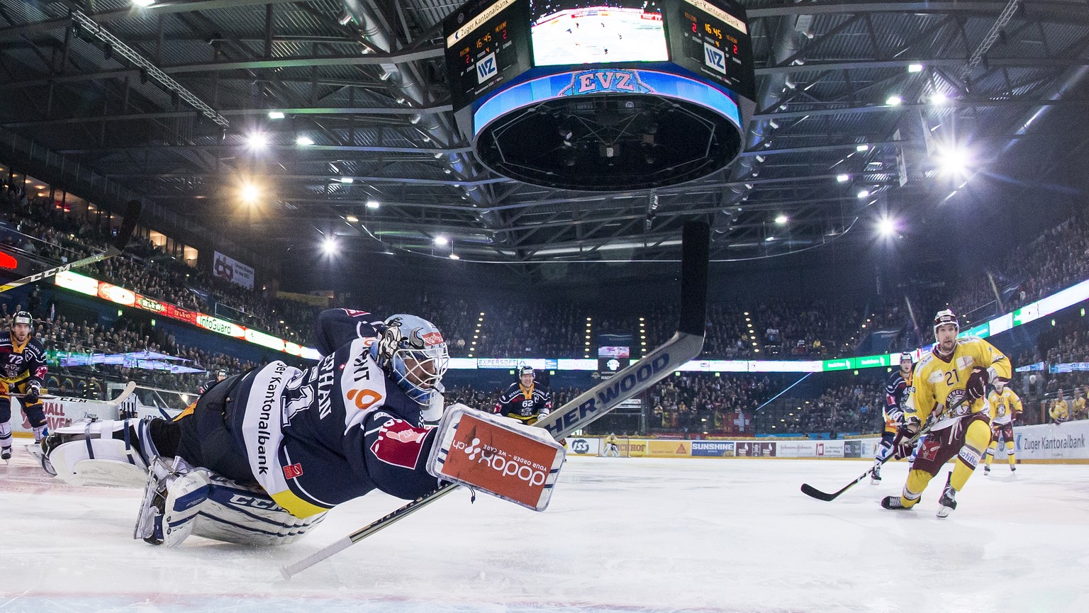 Zugs Torhueter Tobias Stephan, links, kaempft um den Puck gegen Servettes Tim Traber, rechts, im ersten Eishockey Playoff-Viertelfinalspiel der National League A zwischen dem EV Zug und dem Geneve-Ser ...