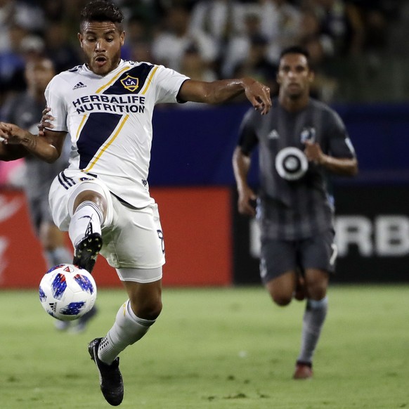 LA Galaxy midfielder Jonathan dos Santos, right, controls the ball next to Minnesota United midfielder Collen Warner during the first half of an MLS soccer match Saturday, Aug. 11, 2018, in Carson, Ca ...