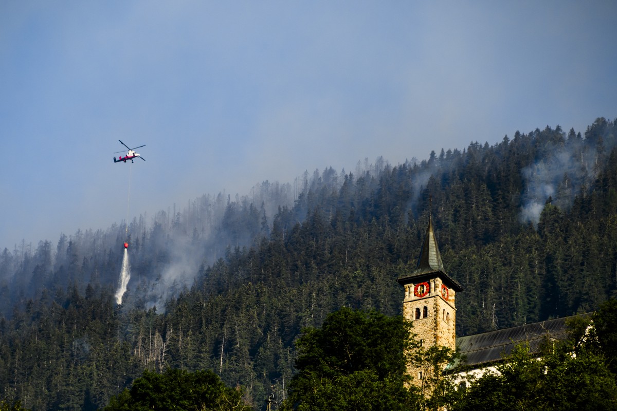 Un helicoptere verse de l'eau sur la fumee qui s'echappe de la foret en feu au dessus des communes de Bitsch et Ried-Moerel le mardi 18 juillet 2023 depuis Ried-Moerel. Les h