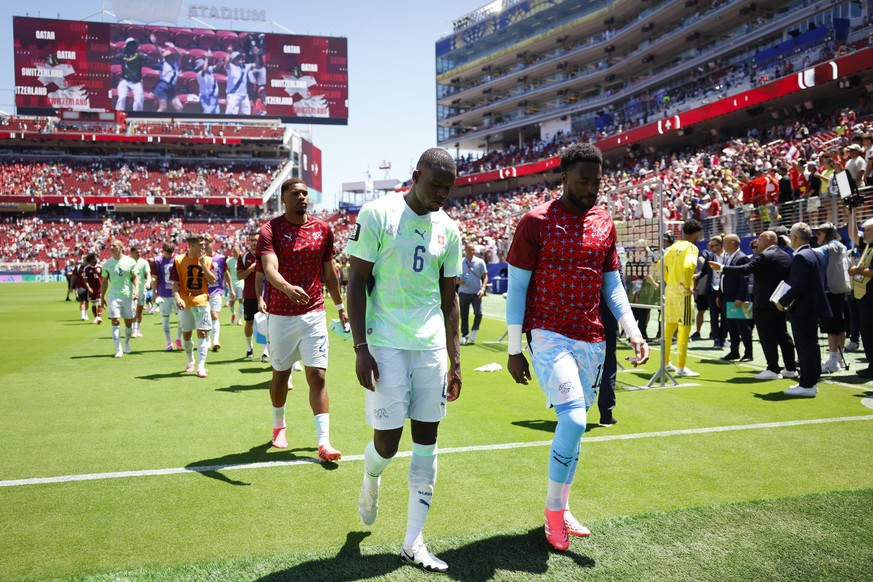 epa13035401 Switzerland's Denis Zakaria, front left, goalkeeper Yvon Mvogo, right, and their teammates leave the pitch after the FIFA World Cup 2026 group stage match Qatar against Switzerland, i ...