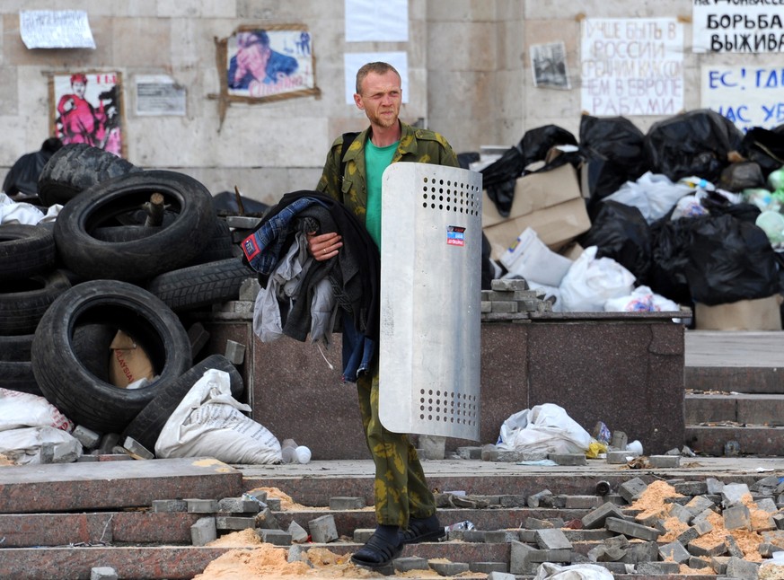 A Pro-Russian rebel carries his belongings - including a riot police shield - as the activists leave the regional administration offices in Donetsk, eastern Ukraine, on May 30, 2014, after having been ...