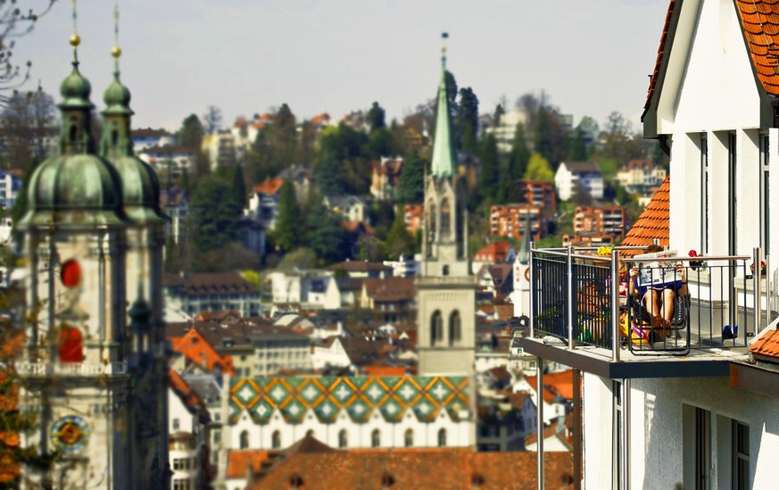 Ein Mann liest am Sonntag, 3. April 2011, oberhalb der Stadt St. Gallen auf seinem Balkon bei fruehsommerlichen Temperaturen eine Zeitung. (KEYSTONE/Ennio Leanza)