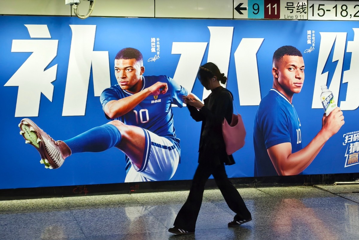 A woman walks by an advertisement featuring French soccer star Kylian Mbappé in Shanghai, China on June 30, 2026. (Chinatopix Via AP) CHINA OUT
China Mbappé
