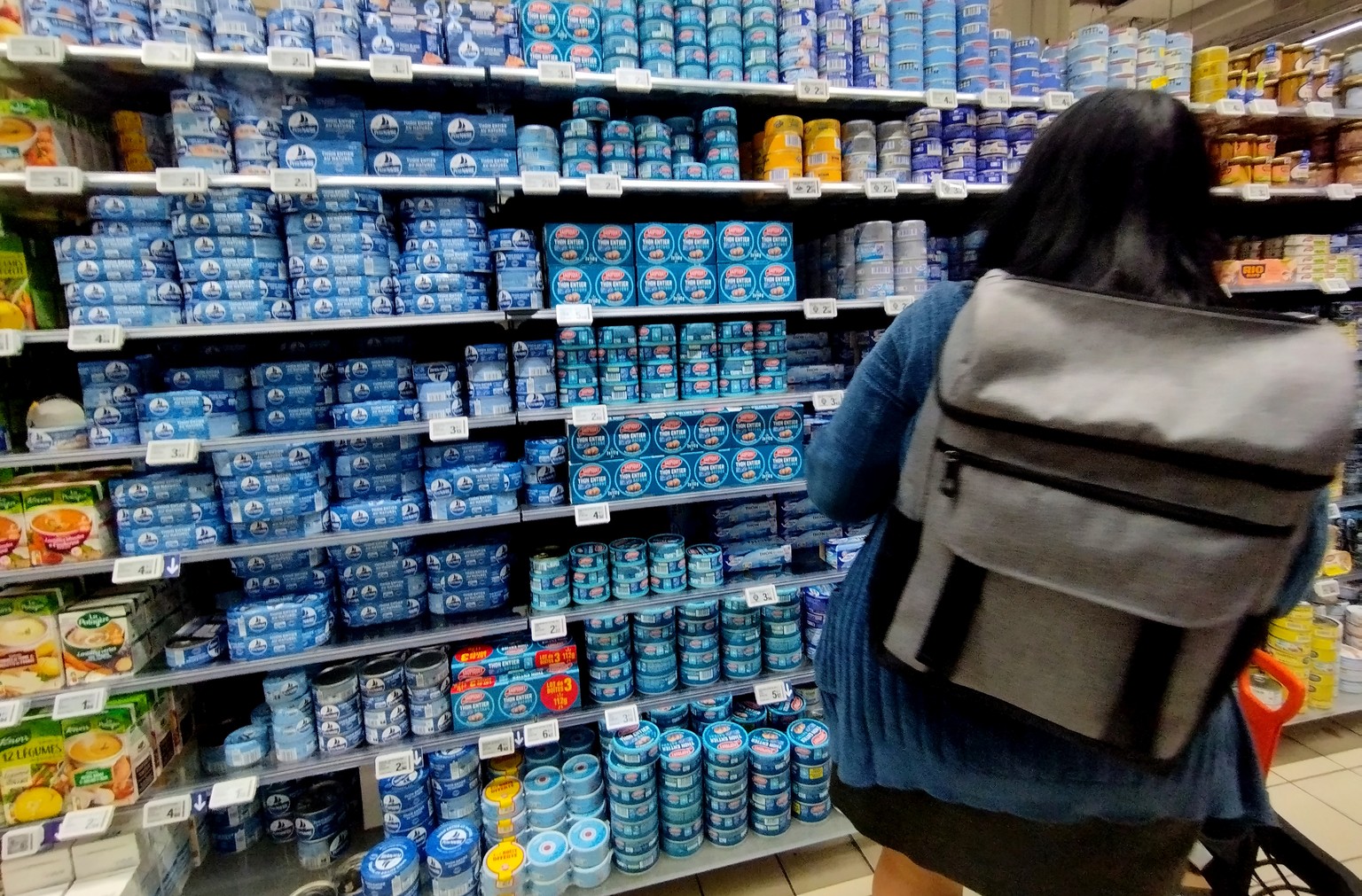 epa11696608 A customer stands in front of a shelf with cans of tuna fish on display for sale at a supermarket in Nice, France, 01 November 2024. Tinned tuna in several European countries is contaminat ...