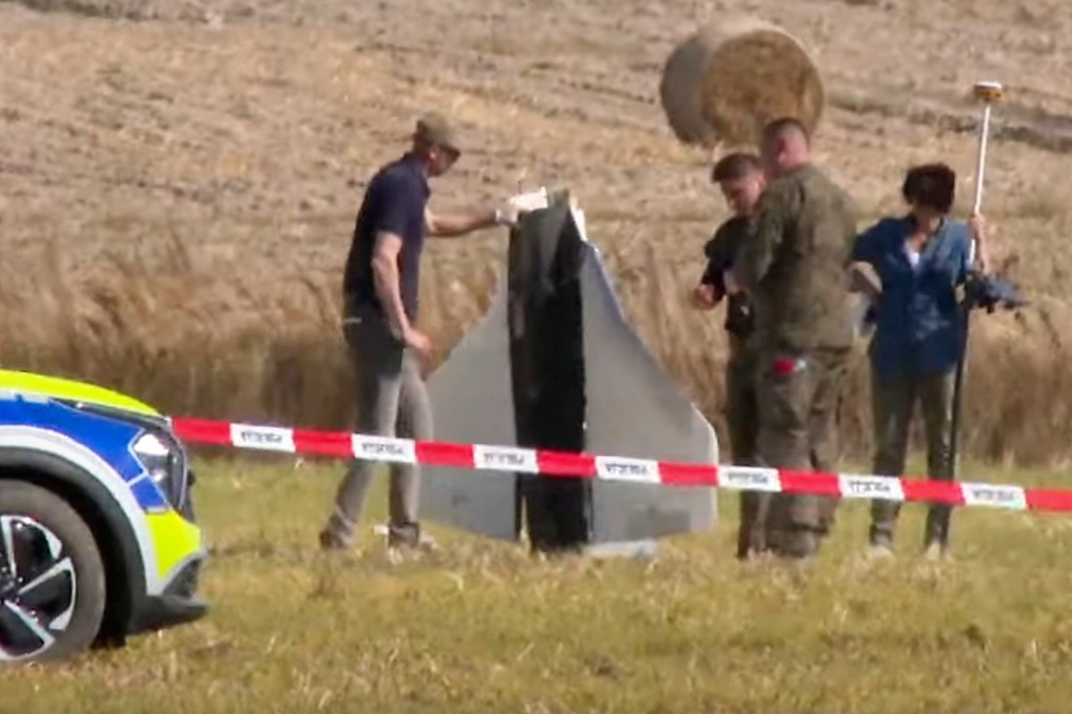 In this image made from video, Police and Military Police secure parts of a damaged object shot down by Polish authorities at a site in Wohyn, Poland, Wednesday, Sept. 10, 2025. (AP Photo/Rafal Niedzi ...