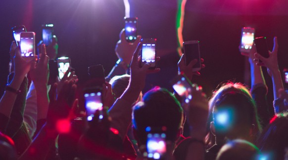 Audience photographing musician on stage