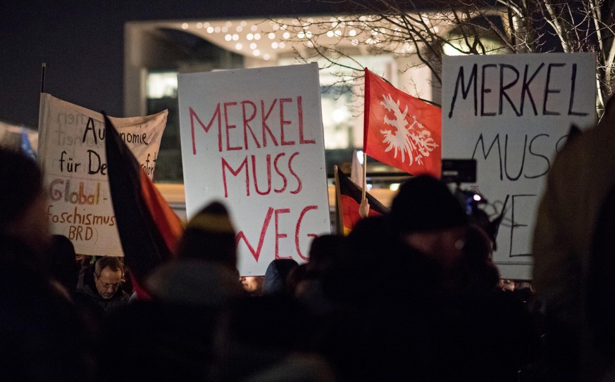epa05684842 Participants of a vigil of right-wing groups are holding a sign that reads &#039;Merkel must go&#039; in front of the German Chancellery in Berlin, Germany, 21 December 2016. They are leve ...