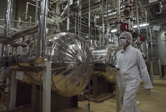 FILE - An Iranian security official in protective clothing walks through part of the Uranium Conversion Facility just outside the Iranian city of Isfahan, March 30, 2005. (AP Photo/Vahid Salemi, File) ...